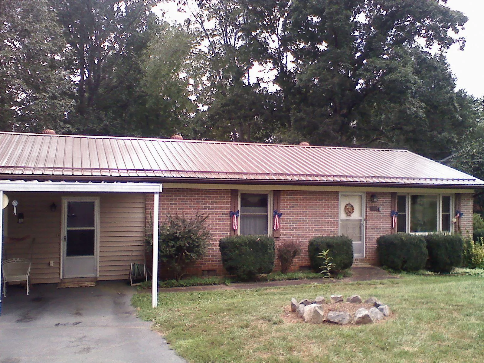 Bronze metal roof and carport on a brick ranch home — Roof Repair work by our crew in Celina